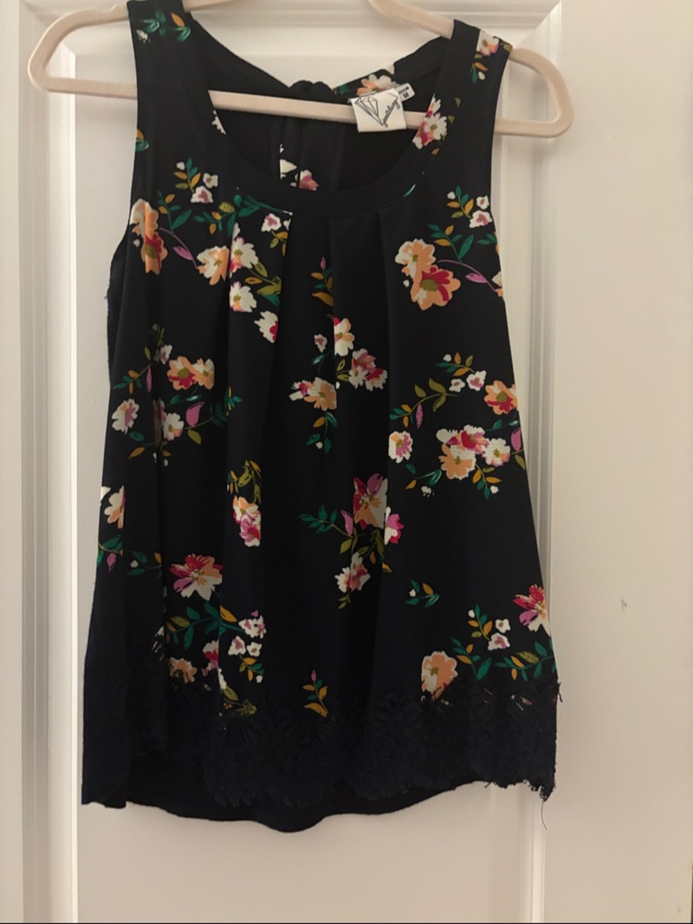 Navy floral top with lace hem and tie at back of neck.